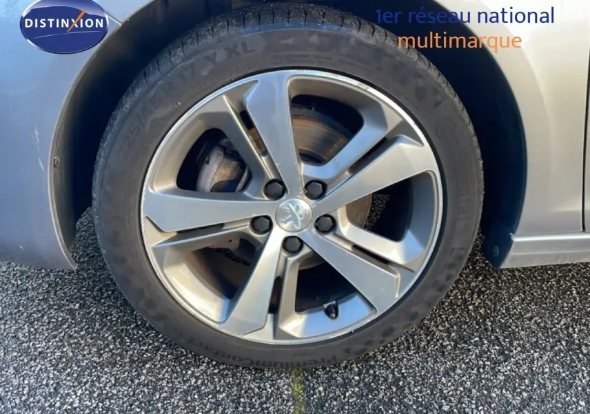 Gros plan sur la roue avant droite d’une Peugeot 308 gris Artense avec jante alliage 17 pouces.