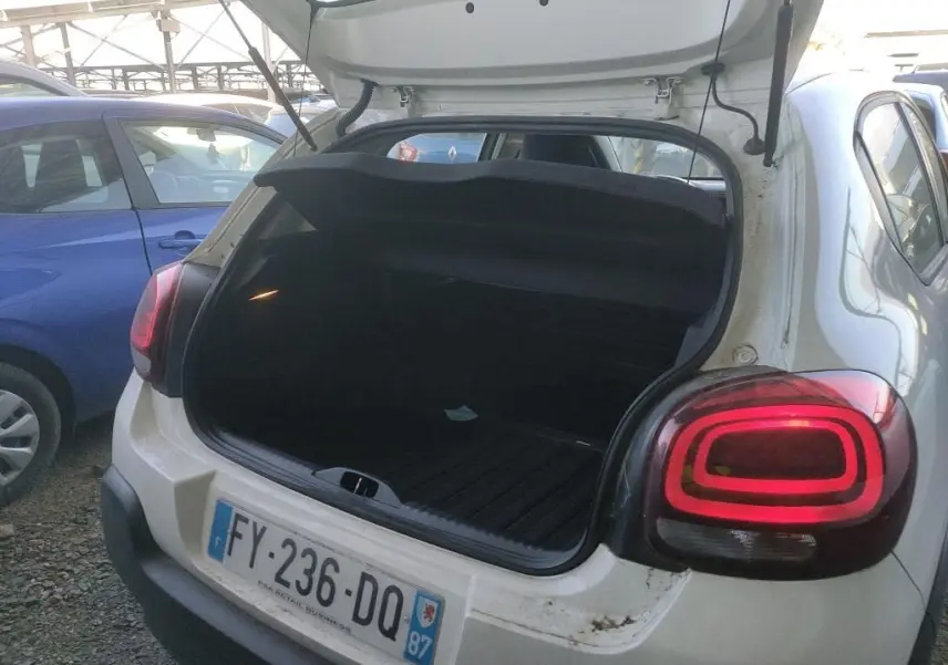 Vue arrière ouverte d'une Citroën C3 Société blanche de 2021, coffre vide avec feux arrière allumés.