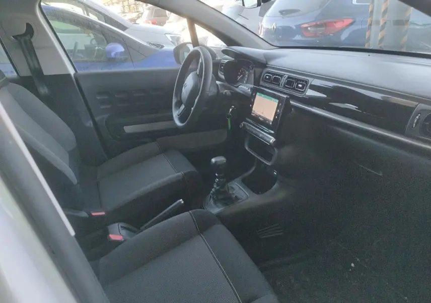 Intérieur de la Citroën C3 Société 2021 vu côté gauche, tableau de bord noir avec écran tactile et sièges tissu gris.