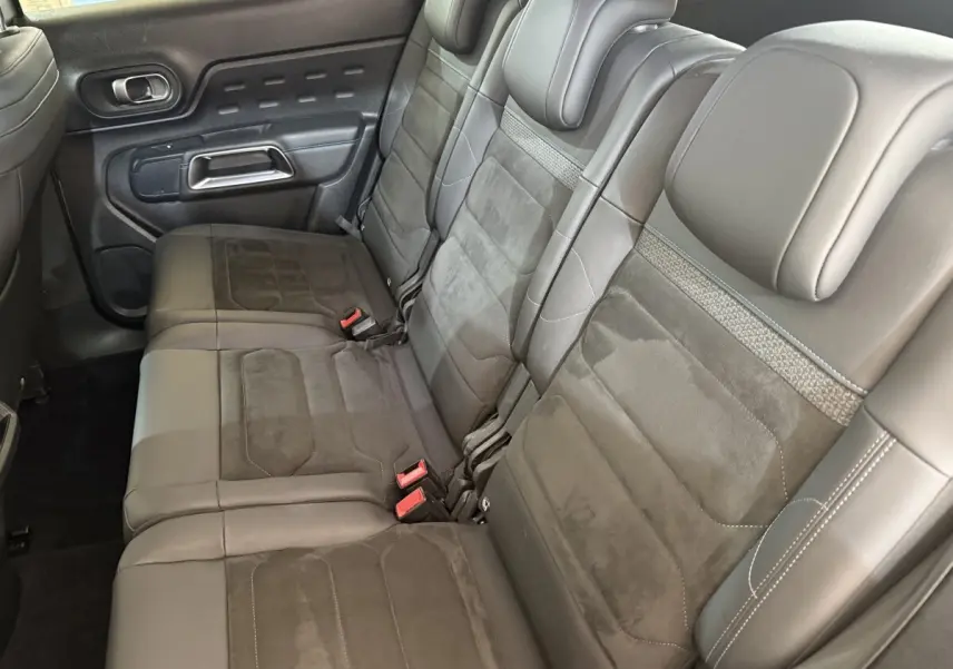 Vue latérale des sièges arrière individuels gris foncé du Citroën C5 Aircross 2023 avec appuie-têtes et ceintures visibles.