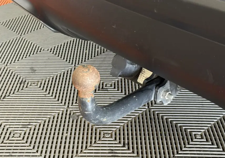 Gros plan sur l'attelage de remorque rouillé sous le pare-chocs arrière gris clair du Citroën C5 Aircross 2023.