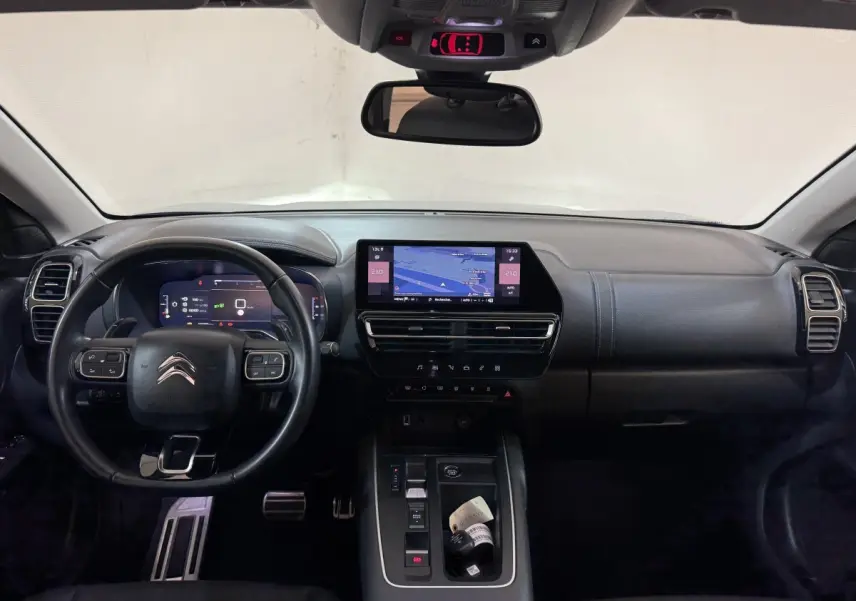 Vue intérieure frontale du tableau de bord noir du Citroën C5 Aircross 2023 avec écran tactile central et volant multifonctions.