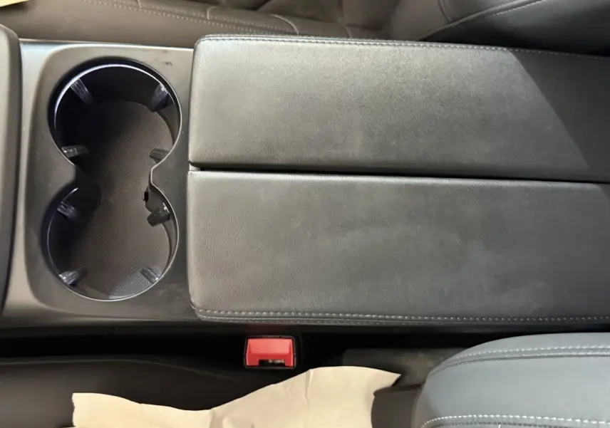 Gros plan sur la console centrale noire avec porte-gobelets et accoudoir du Citroën C5 Aircross gris clair 2023.