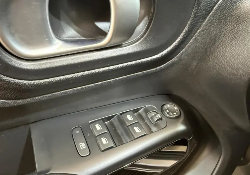 Gros plan sur les commandes de lève-vitres et rétroviseurs côté conducteur d'une Citroën C5 Aircross gris clair 2023.
