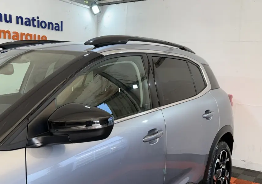 Vue de profil côté gauche sur le CITROEN C5 AIRCROSS gris clair avec rétroviseur noir et barres de toit noires.