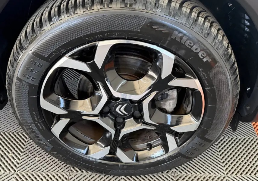 Gros plan sur la roue avant droite d'une Citroën C5 Aircross gris clair, avec pneu 225/55 R18 visible.