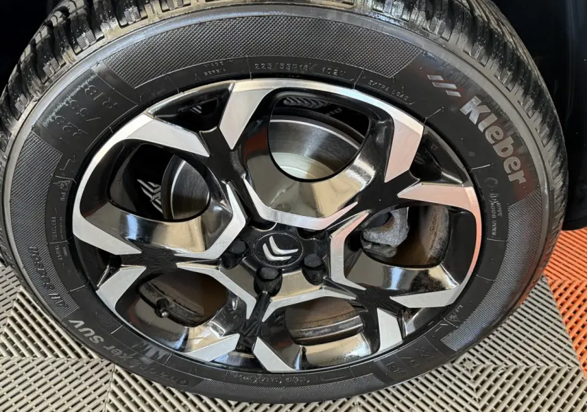 Gros plan sur la jante alliage bicolore noire et argent d’un Citroën C5 Aircross gris clair, vue latérale.