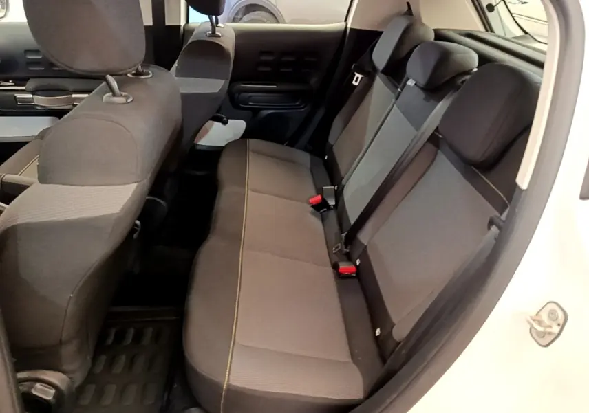Vue intérieure côté droit montrant la banquette arrière grise et noire d'une Citroën C3 blanche 2021.