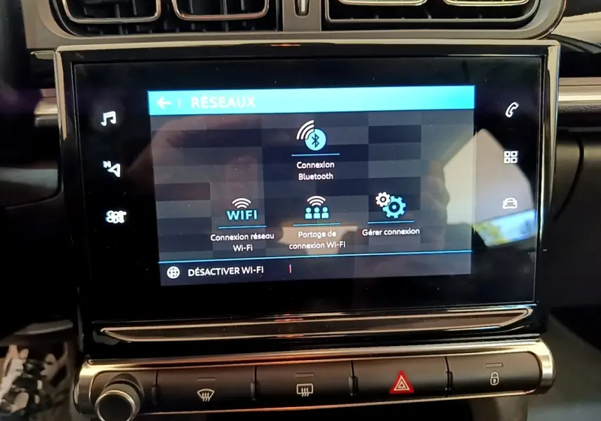 Écran tactile central affichant les options réseau Wi-Fi et Bluetooth dans l’habitacle d’une Citroën C3 blanche.