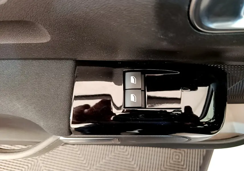 Gros plan sur les commandes de lève-vitres électriques côté conducteur d'une Citroën C3 blanche de 2021.