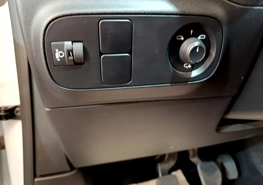Gros plan sur les commandes d'éclairage et réglage des rétroviseurs côté conducteur d'une Citroën C3 blanche 2021.