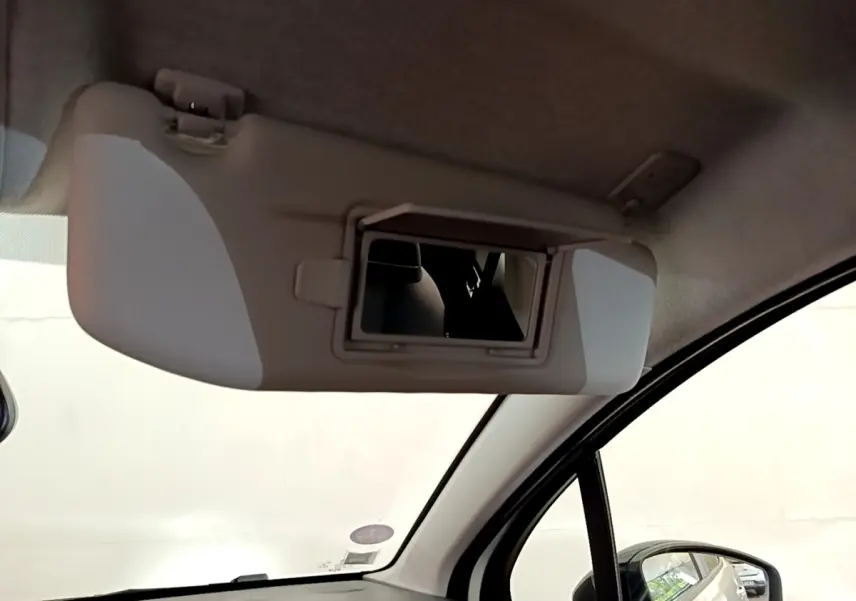 Miroir de courtoisie ouvert sur pare-soleil côté conducteur dans l'habitacle d'une Citroën C3 blanche.