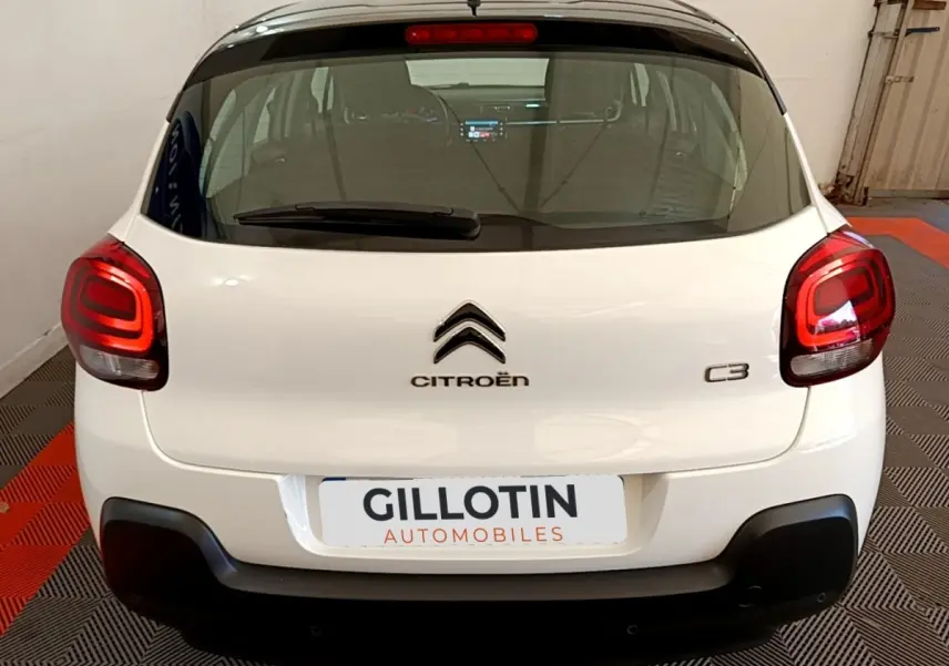 Vue arrière d'une Citroën C3 blanche avec feux arrière LED et logo centré dans un garage.