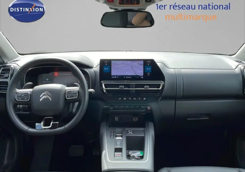 Intérieur avant du Citroën C5 Aircross Hybrid 2025, tableau de bord noir avec écran tactile central et volant multifonction.