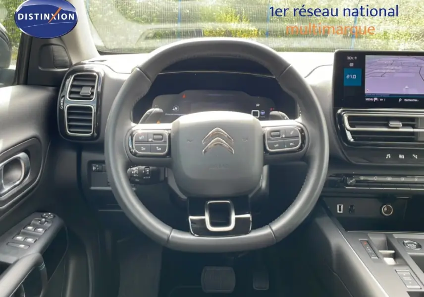 Vue intérieure centrée sur le volant cuir multifonction et tableau de bord numérique du Citroën C5 Aircross 2025.