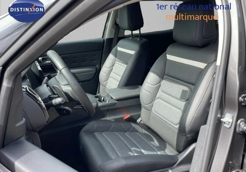 Vue intérieure côté conducteur du Citroën C5 Aircross Hybrid gris platinium, montrant les sièges en tissu et cuir noir.