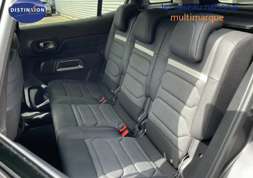 Vue intérieure côté droit montrant la banquette arrière en tissu et cuir noir du Citroën C5 Aircross Hybrid 2025.