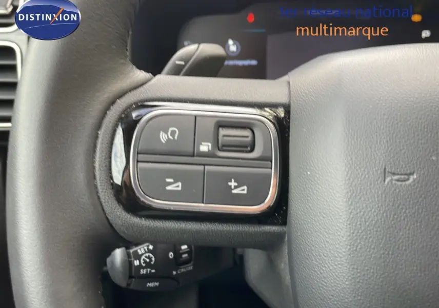 Gros plan sur les commandes au volant du Citroën C5 Aircross Hybrid 2025, finition cuir noir.
