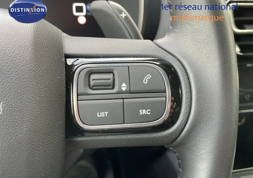 Gros plan sur les commandes gauche du volant en cuir noir du Citroën C5 Aircross Hybrid gris platinium 2025.