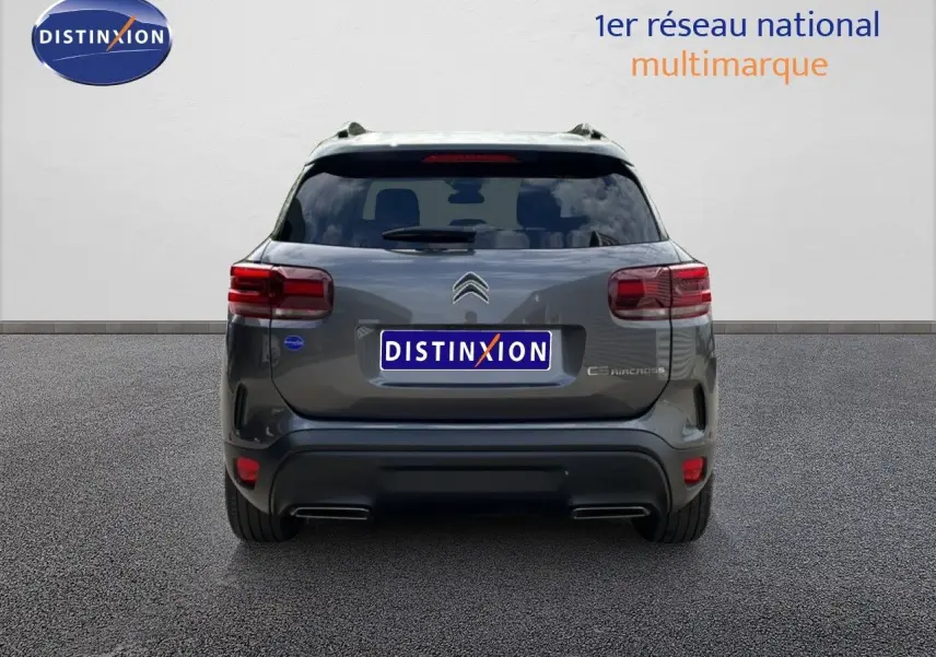 Vue arrière du Citroën C5 Aircross Hybrid gris platinium métal, avec feux rouges et double sortie d’échappement intégrée.
