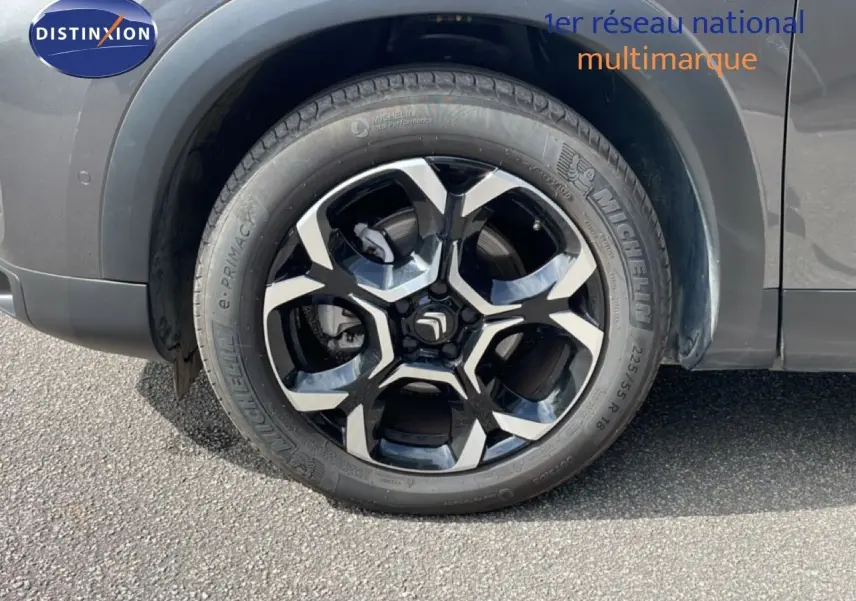 Gros plan sur la roue avant droite gris platinium métal du Citroën C5 Aircross Hybrid 2025 avec jante noire et argentée.
