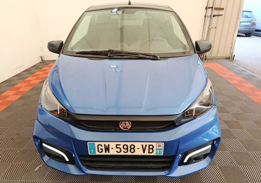 Vue avant d'une Aixam Ambition 0.5 City Sport 2024 bleu avec rétroviseur côté gauche et feux LED diurnes allumés.