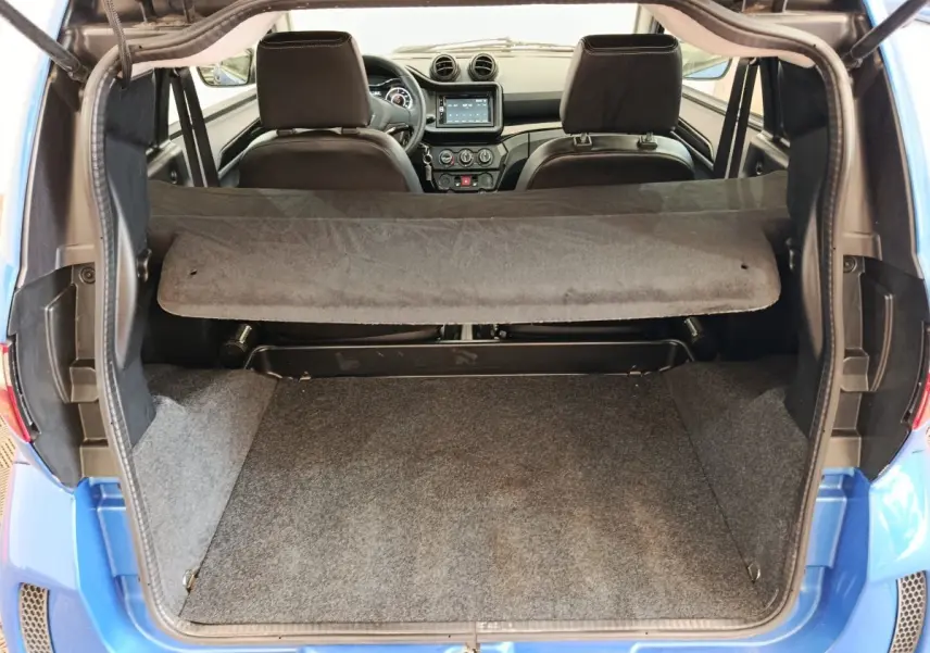 Coffre ouvert d’une Aixam Ambition 0.5 City Sport bleu, vue arrière montrant l’intérieur et tableau de bord.