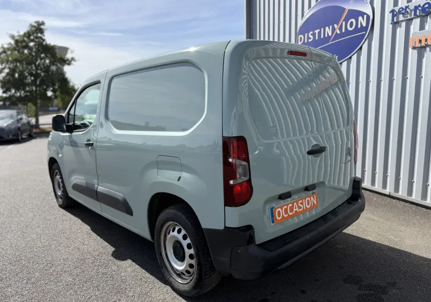 Vue 3/4 arrière droite d’un Citroën Berlingo beige, utilitaire avec porte latérale pleine et plaque occasion.