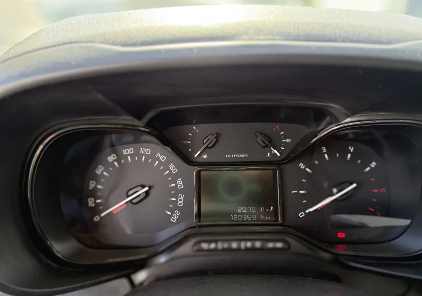 Vue rapprochée du tableau de bord du Citroën Berlingo beige, affichant compteur et jauges digitales.
