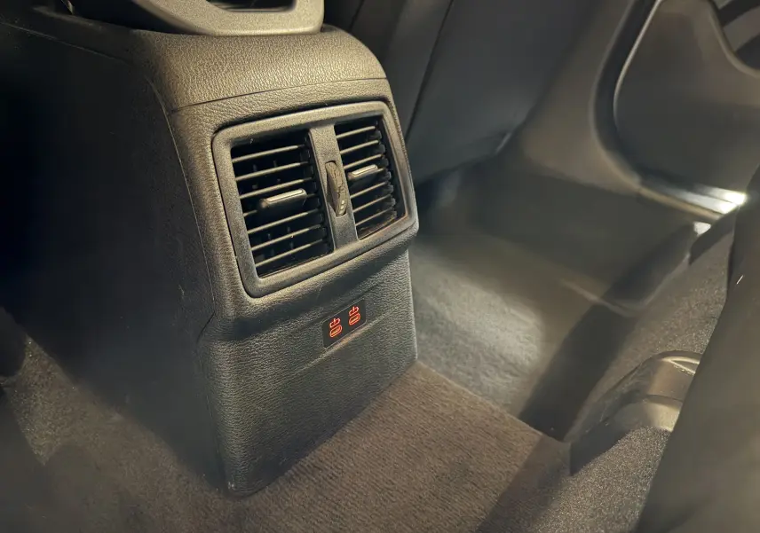 Détail de la console arrière noire avec bouches d’aération et prises USB rouges dans un BMW X2 blanc.