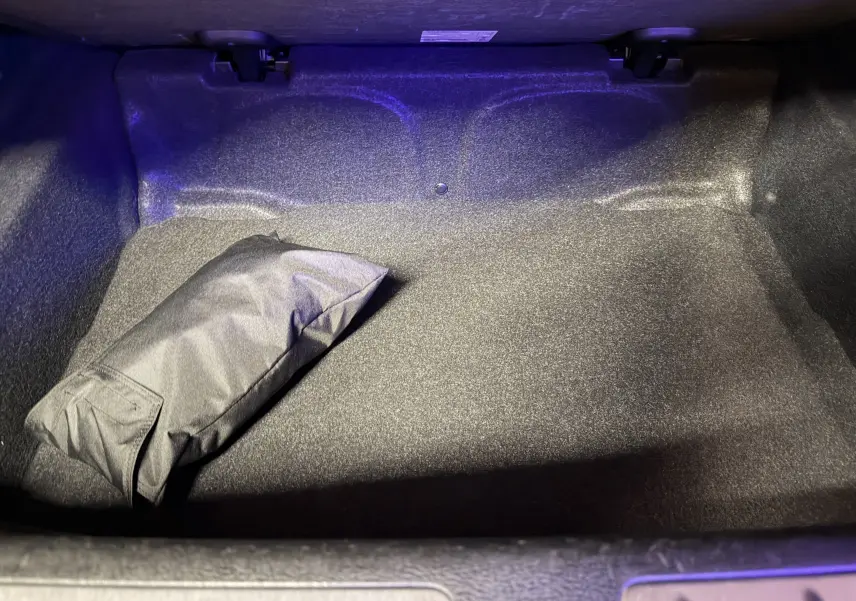 Coffre ouvert vu de face, intérieur noir avec un sac noir posé, BMW X2 sDrive18d blanc 2023.