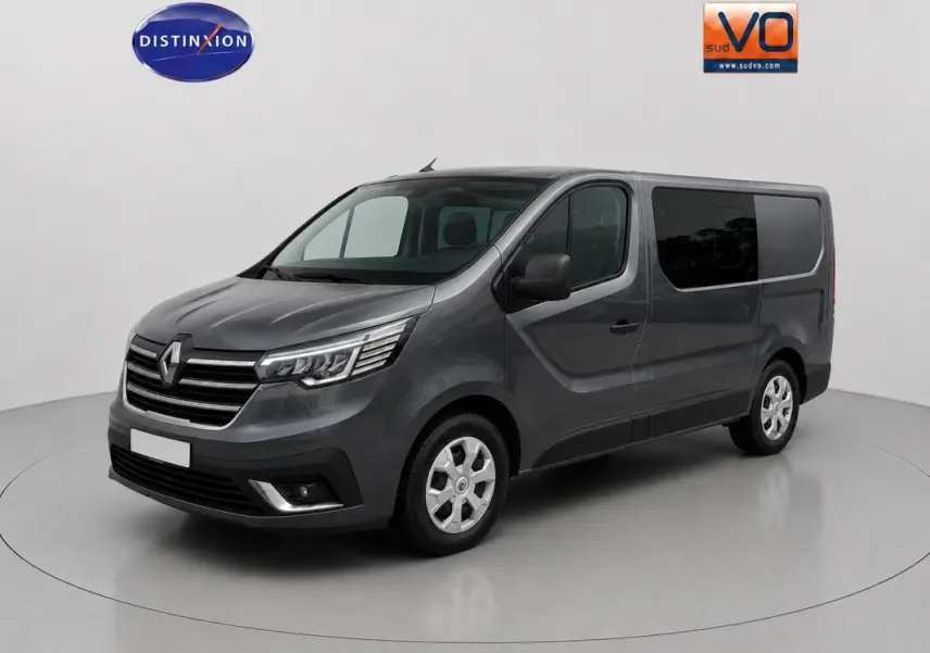 Renault Trafic Fourgon gris foncé en 3/4 avant droit, avec vitres surteintées et porte latérale visible.