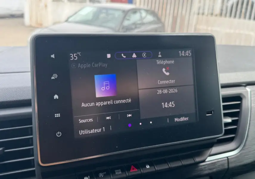 Écran tactile central du Renault Trafic Fourgon gris foncé, vue intérieure du tableau de bord avec commandes visibles.