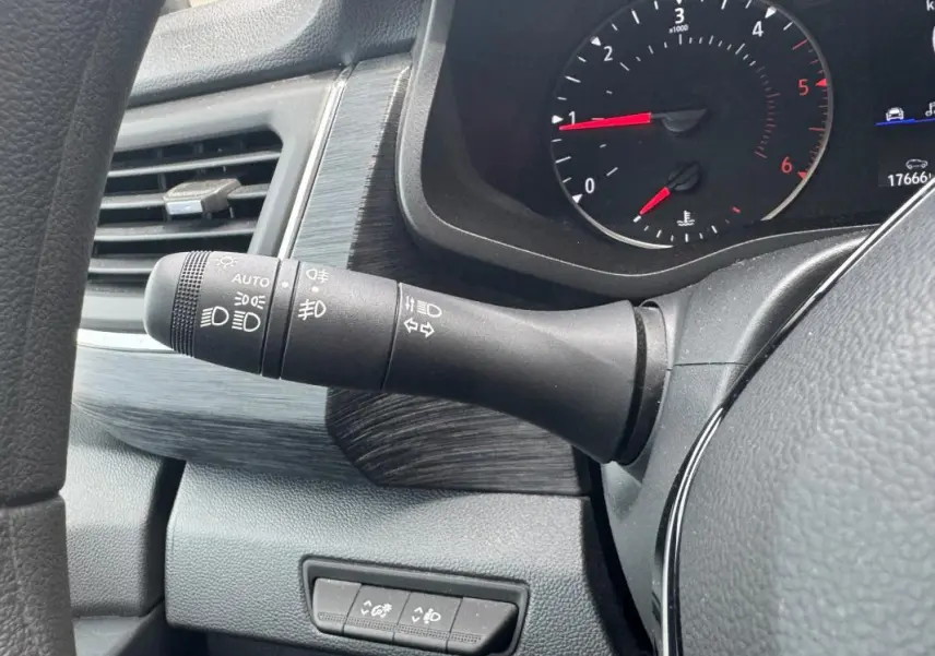 Gros plan sur la commande des feux et clignotants à gauche du volant dans l'habitacle du Renault Trafic Fourgon gris foncé.