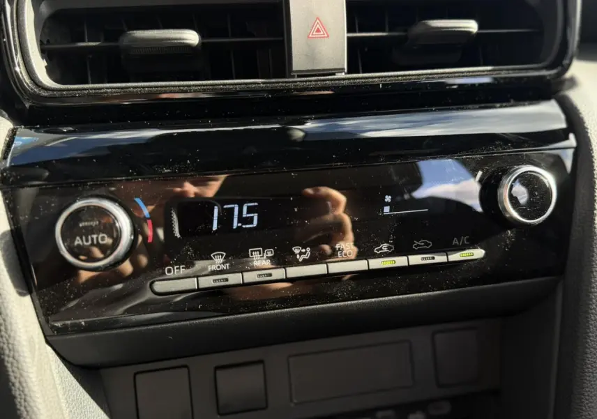 Gros plan sur la console de climatisation automatique noire du Toyota Yaris Cross 2026 avec affichage digital et commandes tactiles.