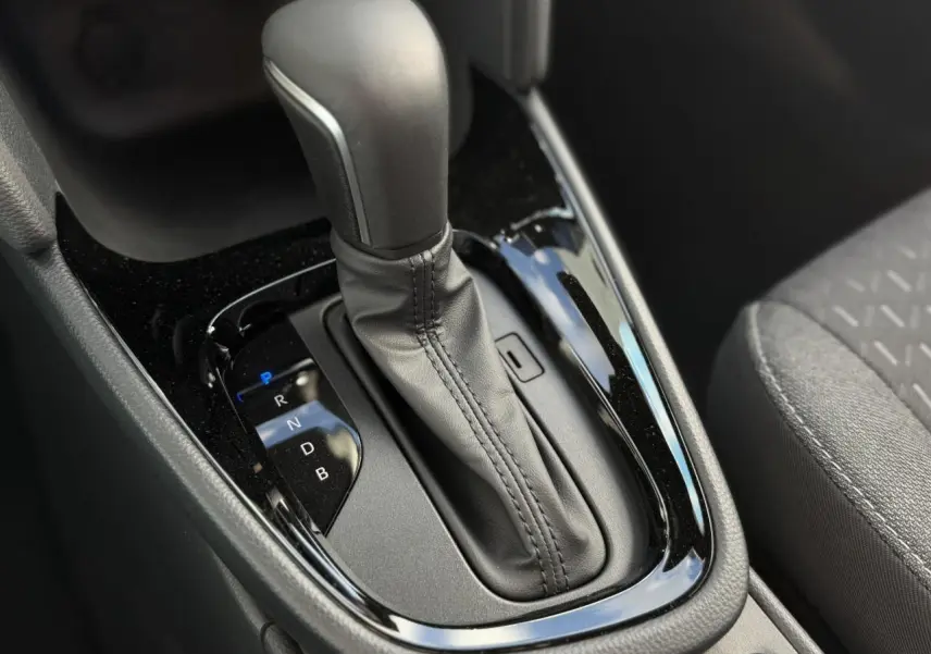 Gros plan sur la commande de la boîte automatique noire dans l'habitacle de la Toyota Yaris Cross 1.5 Hybrid.