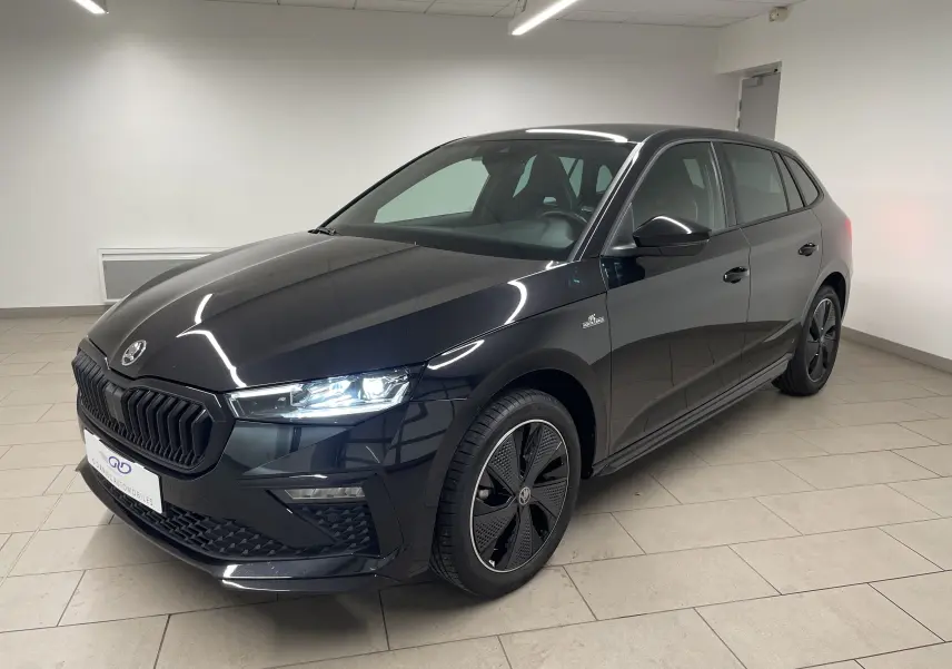 Vue 3/4 avant droite d’une Skoda Scala 1.5 TSI 150 DSG7 Monte-Carlo en noir Magic métallisé, avec jantes spécifiques et phares allumés.