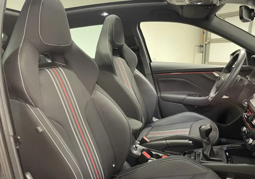 Vue intérieure côté gauche montrant les sièges sport noirs avec bandes grises et rouges du Skoda Scala Monte-Carlo 2025.