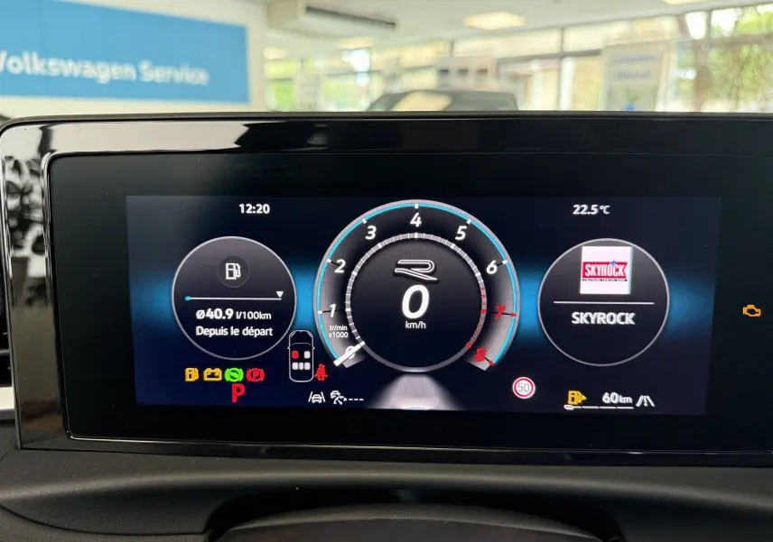 Écran numérique du tableau de bord du Volkswagen T-Roc R-Line noir, affichant vitesse, consommation et radio Skyrock.