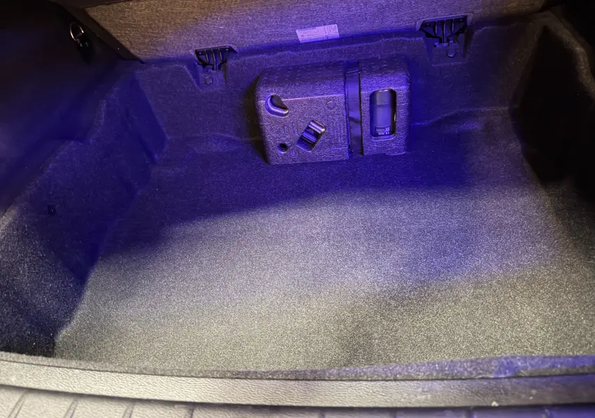 Coffre vide éclairé en bleu du BMW X1 F48 noir 2019, vue intérieure arrière avec rangement intégré visible.