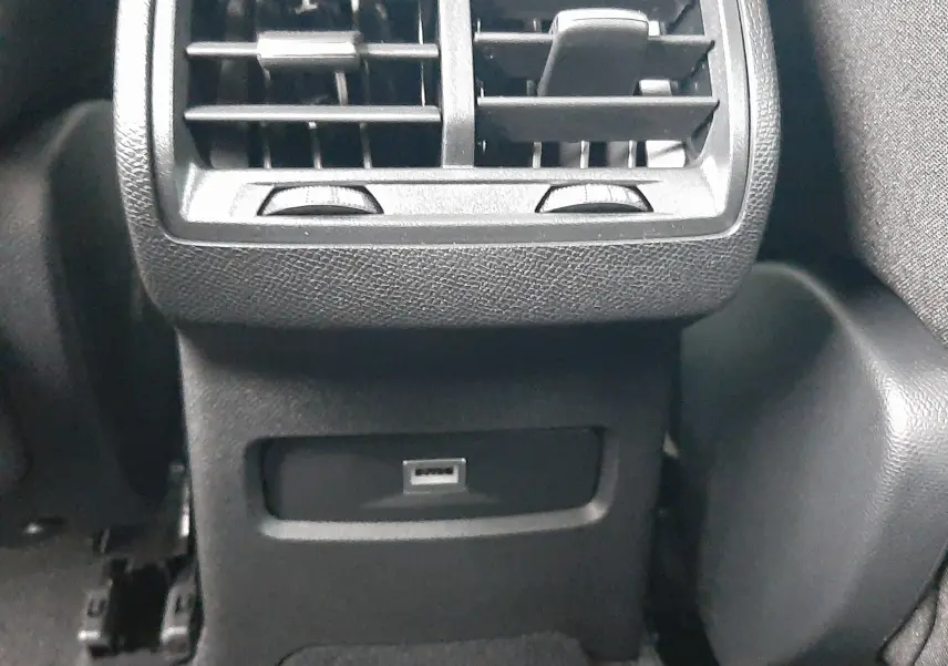 Détail intérieur montrant les aérateurs arrière et une prise USB du Citroën C4 1.2 Hybrid blanc Okenite.