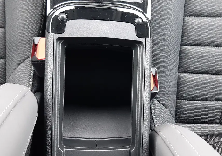 Vue plongeante sur la console centrale noire entre les sièges avant gris du Citroën C4 hybride 2026.