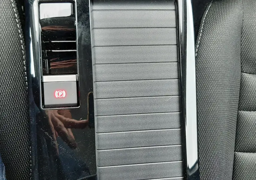 Vue rapprochée de la console centrale noire avec frein à main électronique et accoudoir du Citroën C4 blanc Okenite.