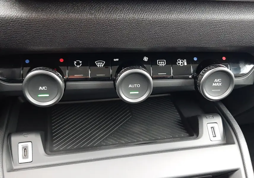 Gros plan sur la console centrale de la Citroën C4 blanche, montrant les commandes de climatisation et ports USB.