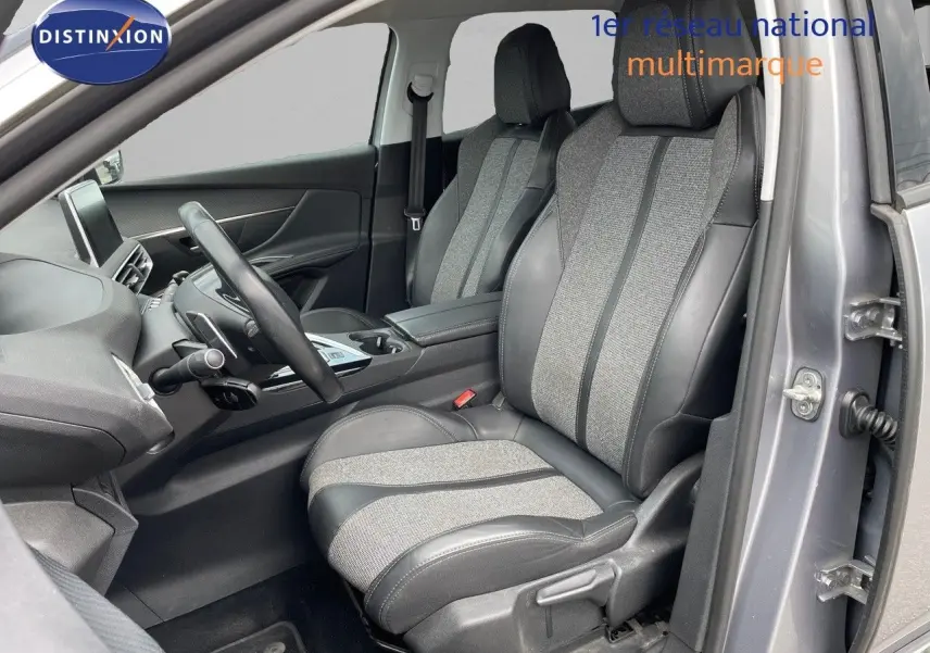 Intérieur avant droit du Peugeot 3008 gris Artense, sièges en cuir et tissu gris, volant multifonction visible.