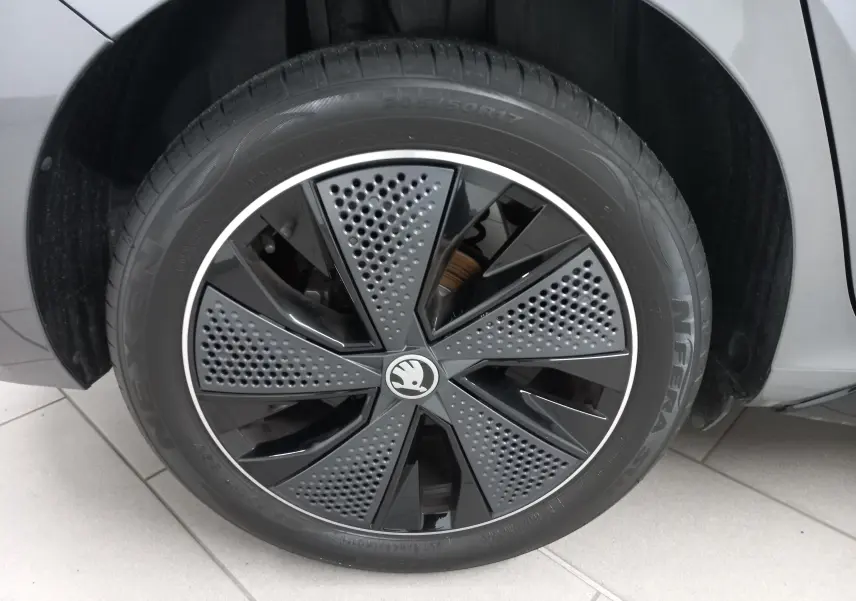 Gros plan sur la roue avant gauche d'une SKODA SCALA 2025 gris graphite avec jante noire au design perforé.