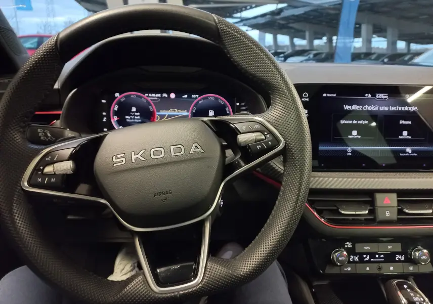 Vue intérieure centrée sur le volant SKODA d'une Scala 1.5 TSI Monte-Carlo avec tableau de bord numérique et écran tactile.