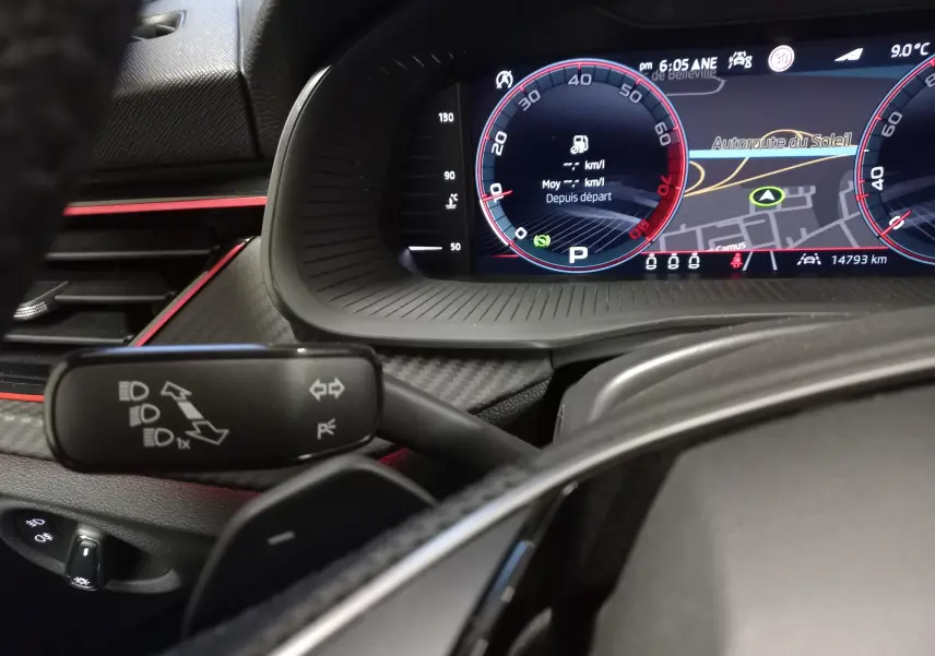 Tableau de bord numérique et commodo de clignotants dans l'habitacle d'une Skoda Scala 1.5 TSI 150 DSG7 Monte-Carlo 2025.