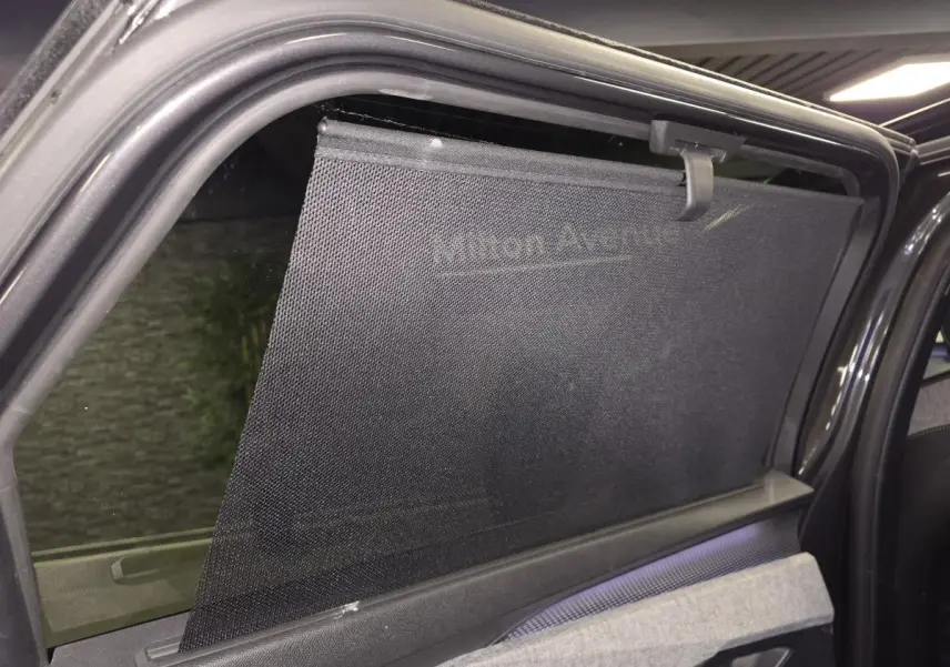 Vue intérieure sur la portière arrière droite du Peugeot 5008 gris avec store pare-soleil déployé.