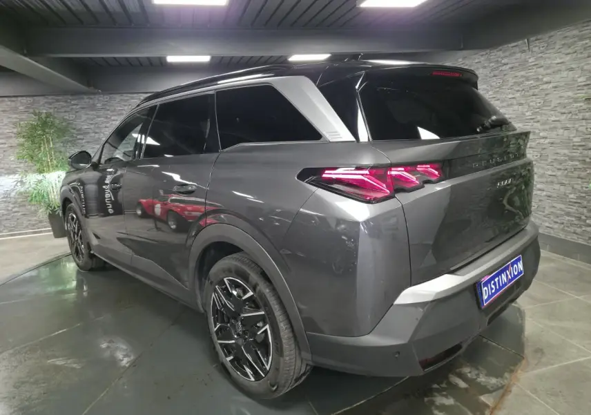 Vue 3/4 arrière droite du Peugeot 5008 gris métallisé avec feux arrière LED 3 griffes et jantes alliage noires.